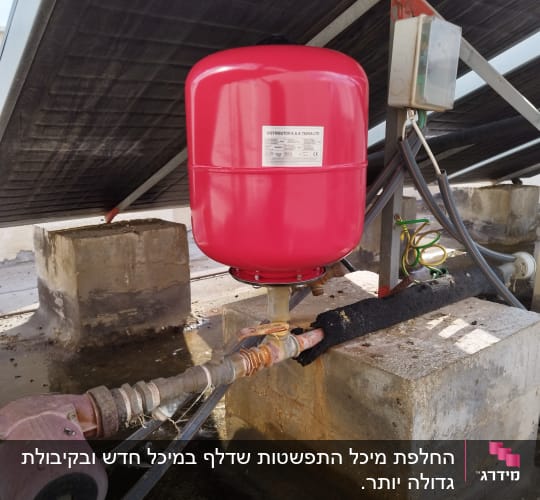 מיכל אדום ומערכת צינורות מתחת לפאנל סולארי